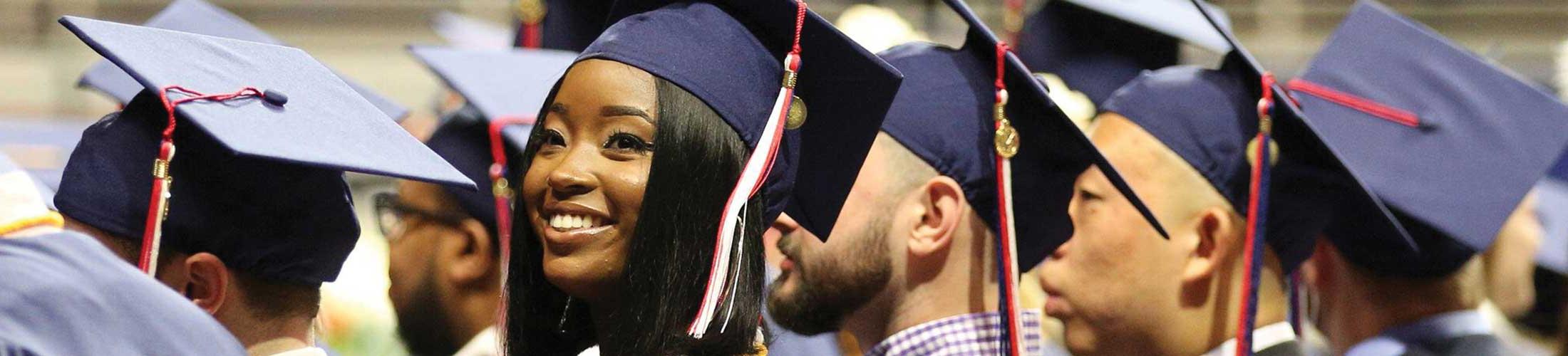 Students smiling in cap and gown.